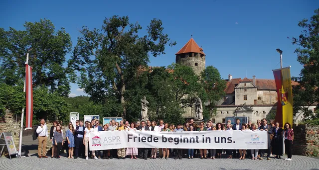 Teilnehmer*innen mit Banner vor der Burg Schlaining